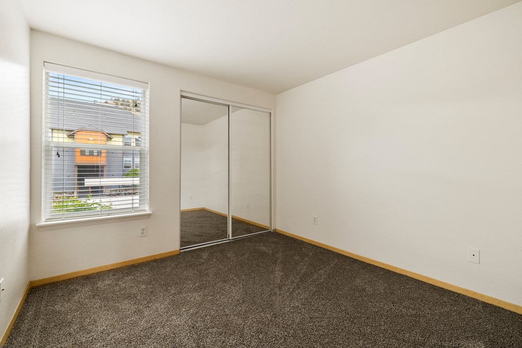 a living room with a window and a door to a closet