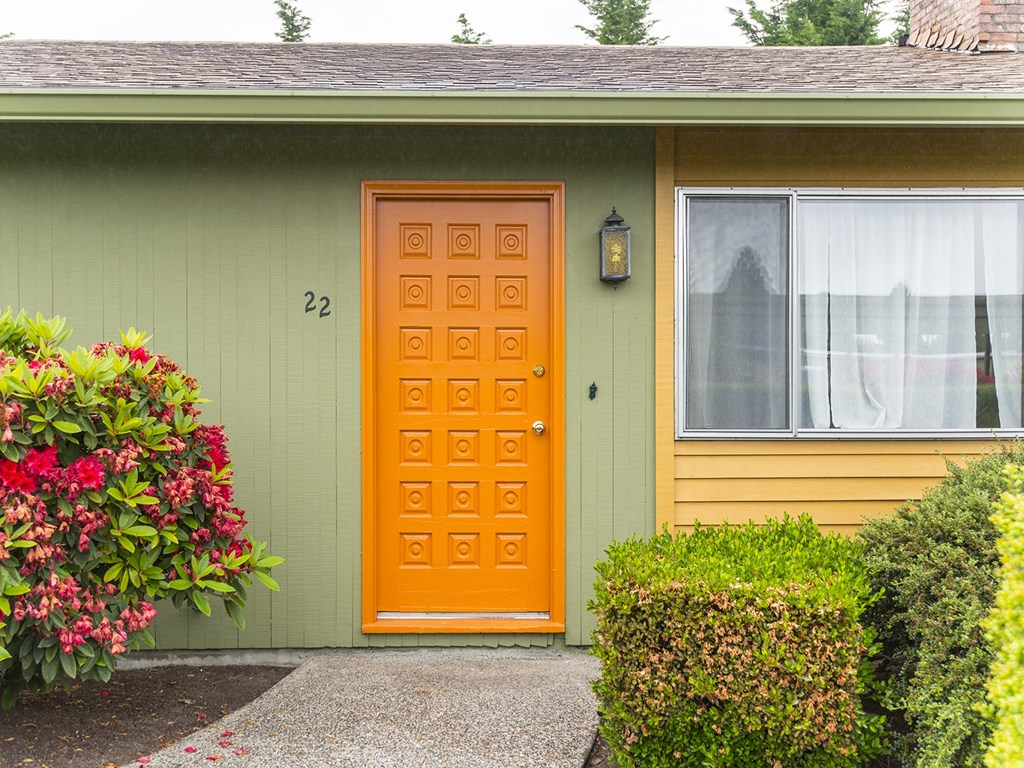 the front of a house with an orange door