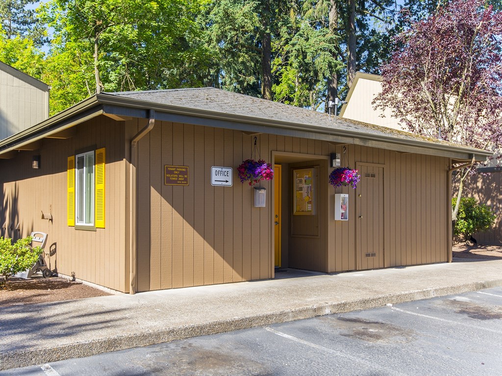 a small brown building with a door and a sign on it