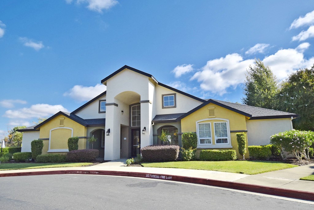 a house with yellow and white exterior and a driveway
