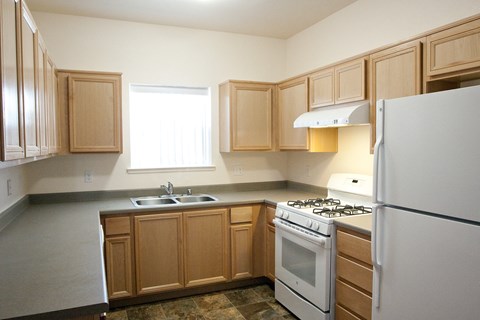 a kitchen with white appliances and wooden cabinets