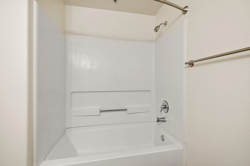 a white bathroom with a tub and a shower
