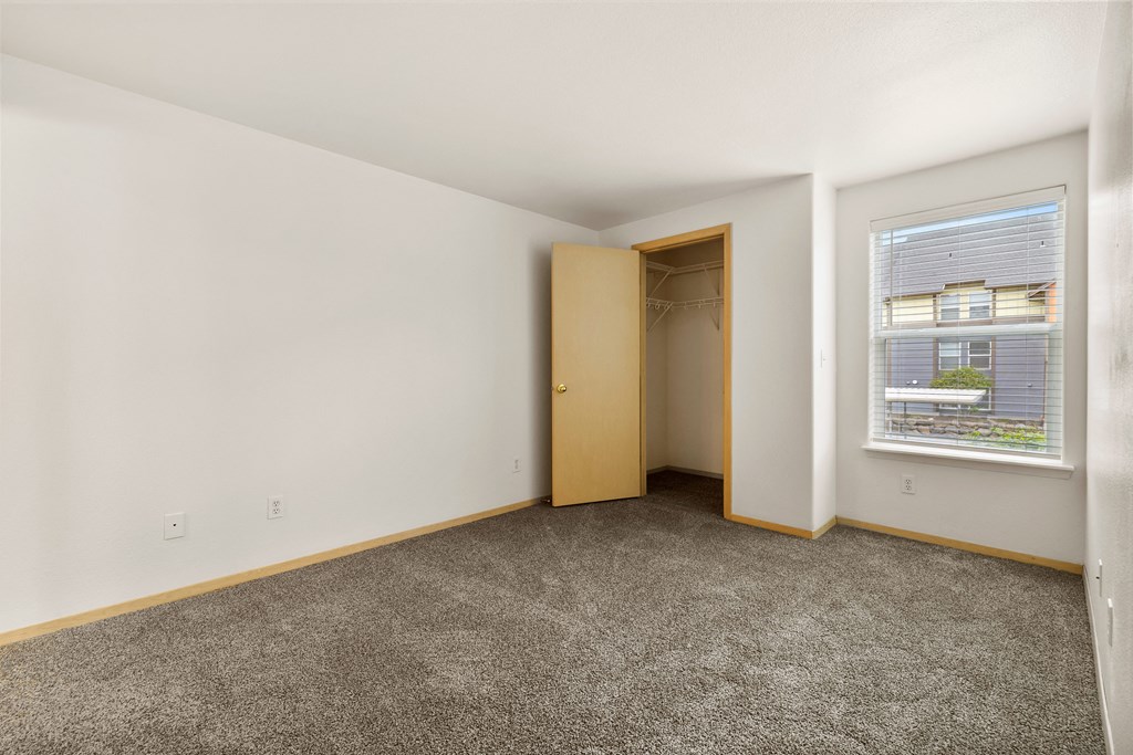 a living room with carpet and a door to a closet