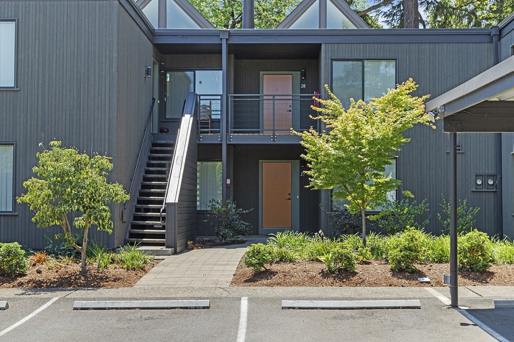 A modern house with a grey exterior and a wooden door.