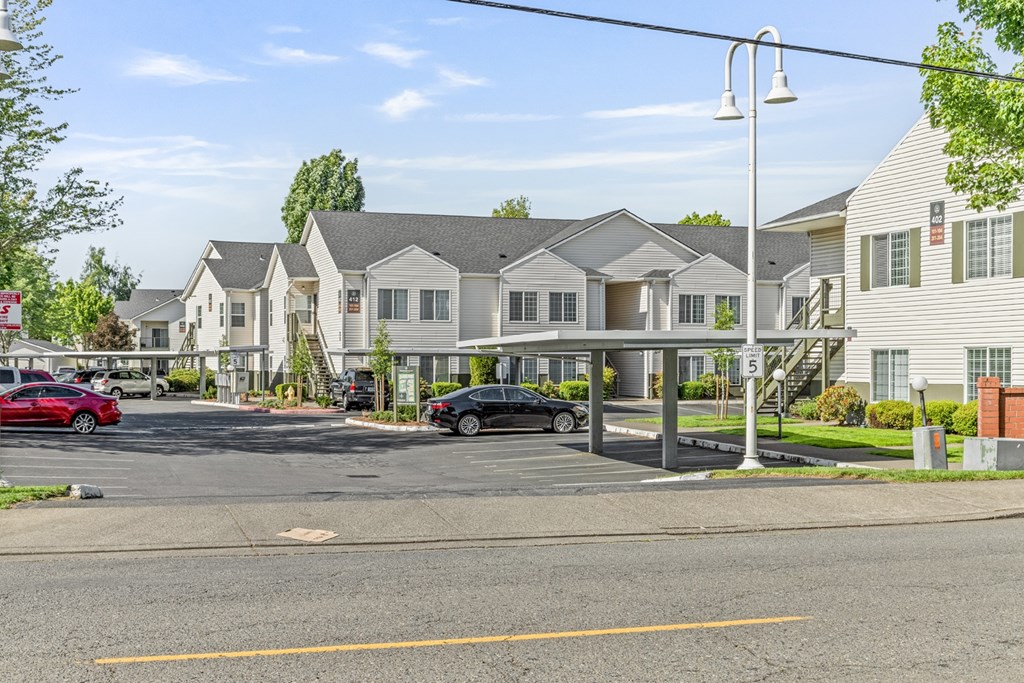 A row of houses with cars parked in front.