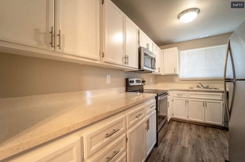 a kitchen with white cabinets and a sink and a refrigerator