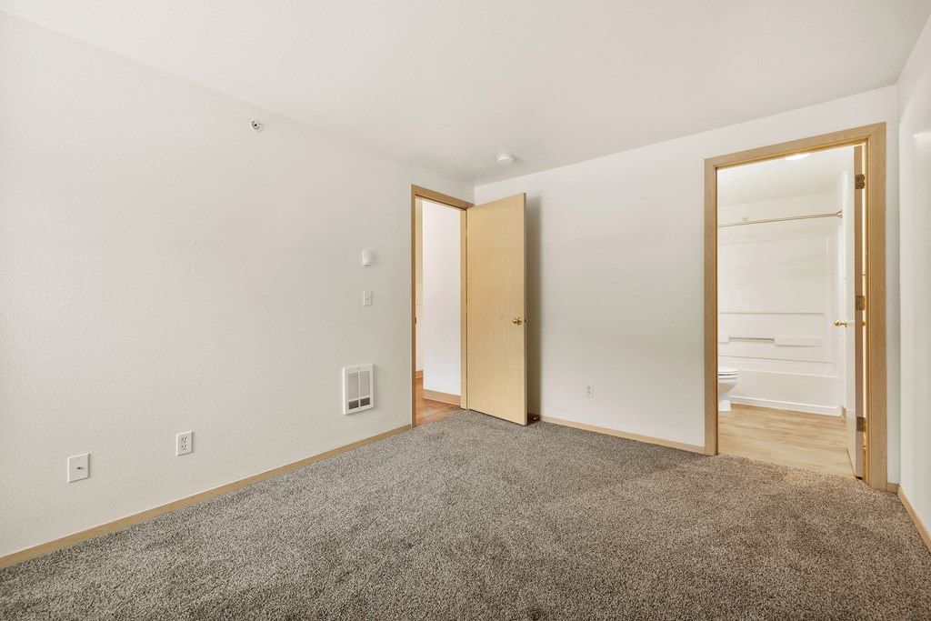 a living room with carpet and a door to a bathroom