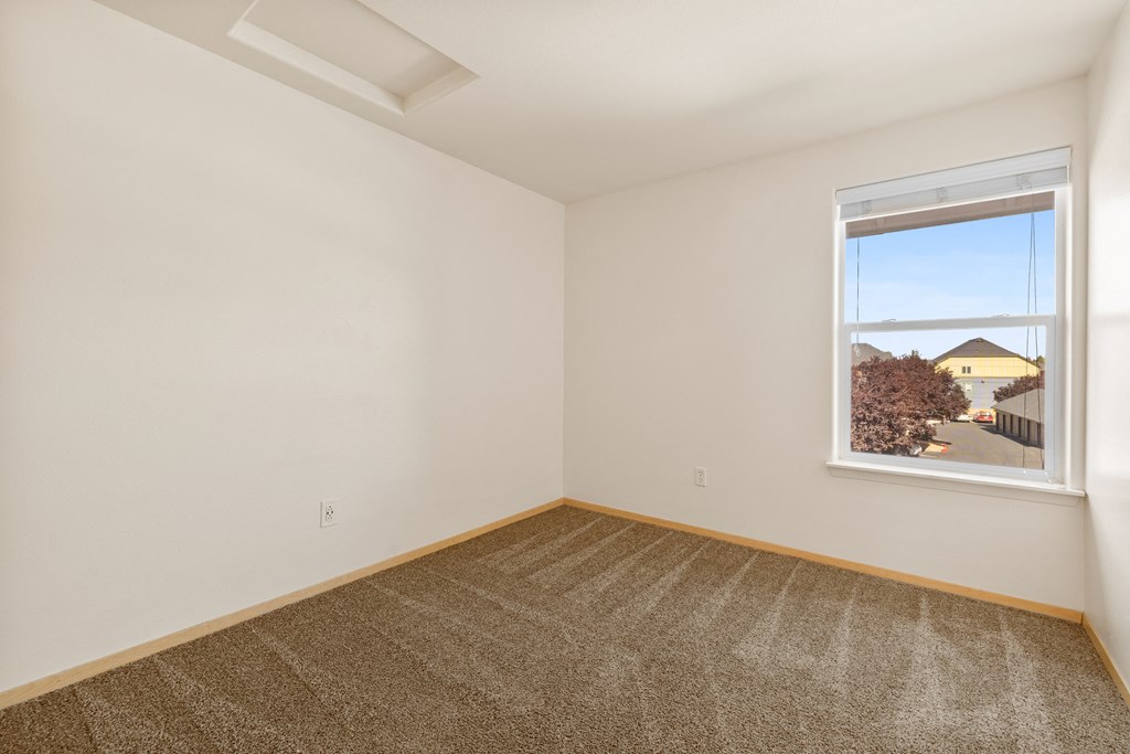an empty room with a window and a carpet