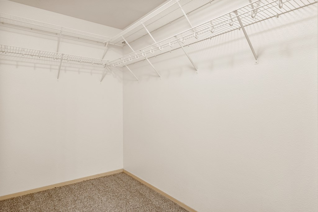 an empty room with white walls and white hangers on the ceiling