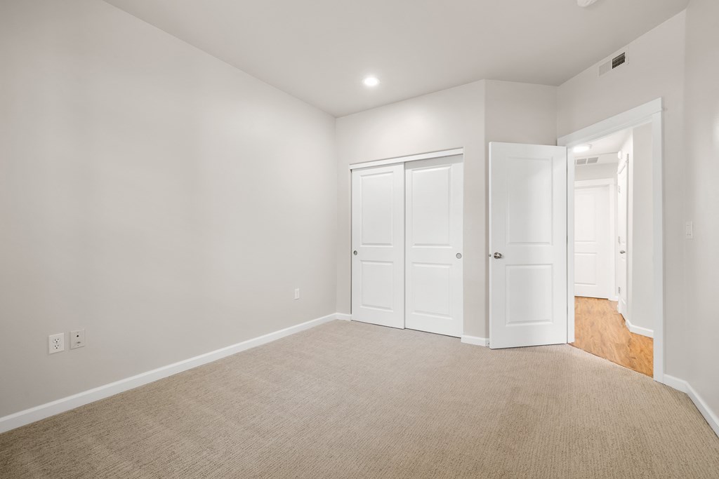 a living room with white walls and white doors and carpet