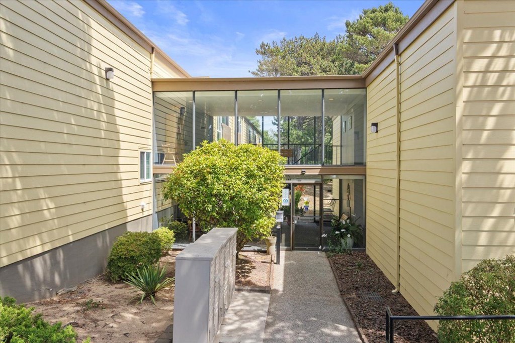 A modern house with a glass door and a small garden.