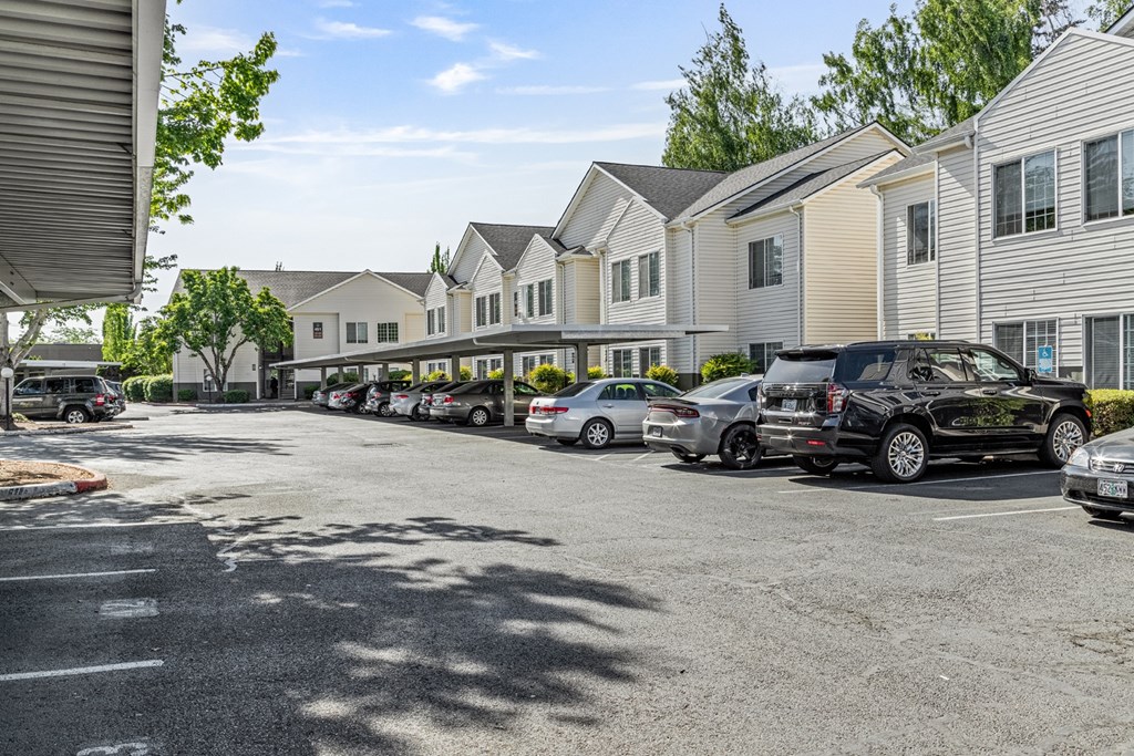 A parking lot with cars and apartment buildings in the background.
