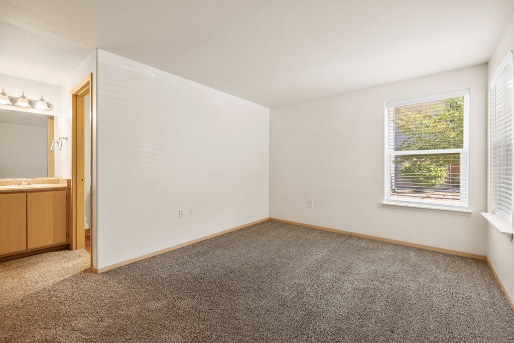 a bedroom with carpet and a window and a sink