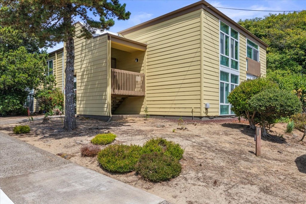 A yellow house with a balcony and a green door.