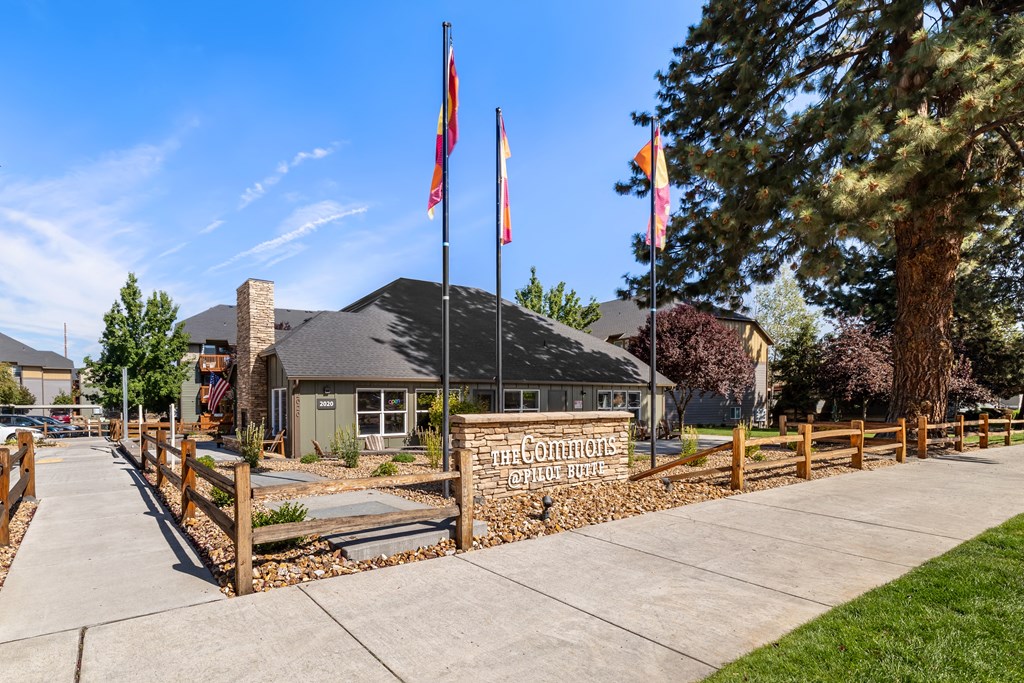a building with flags and a sidewalk in front of it