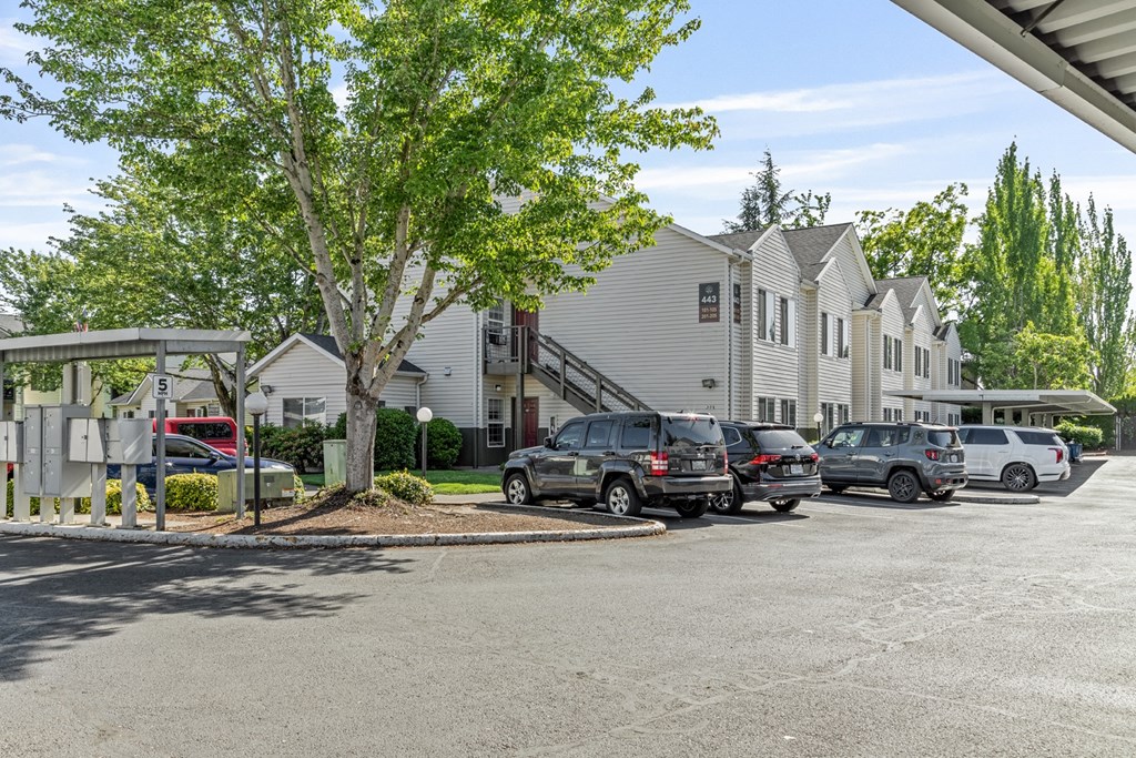 A parking lot with cars and a building in the background.
