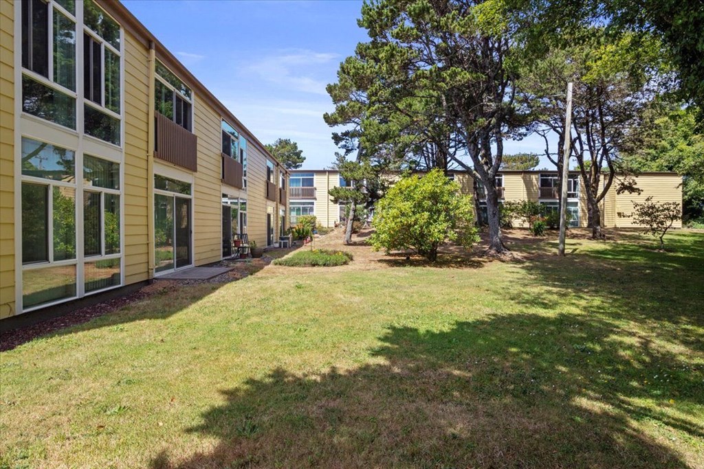A sunny day at a grassy courtyard surrounded by buildings.