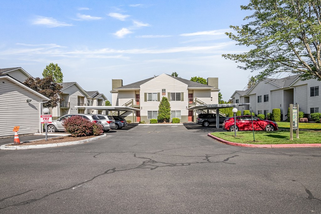 A red car is parked in front of a house in a residential area.