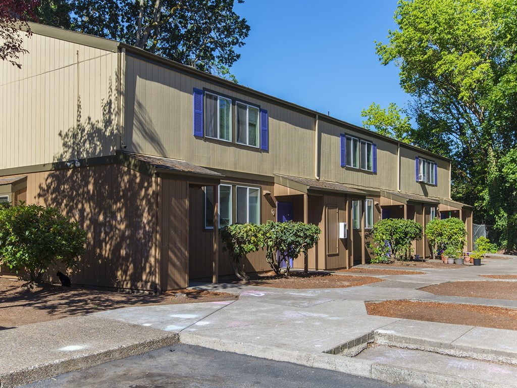 the exterior of a building with a parking lot and trees