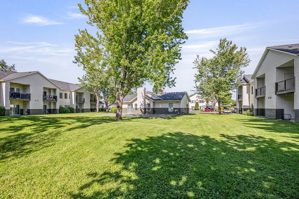 A grassy area in front of apartment buildings.