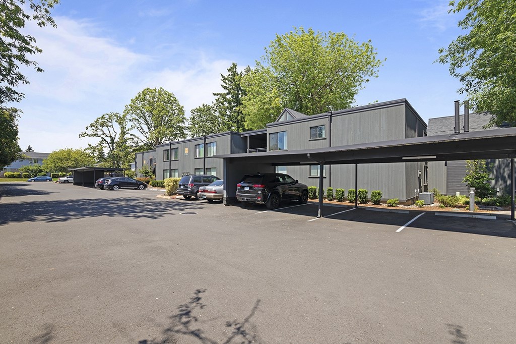A parking lot with cars and a building in the background.