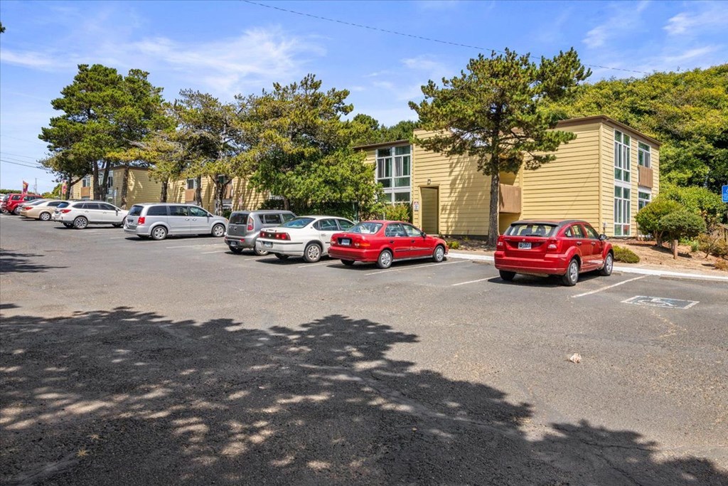 A parking lot with cars and a building in the background.