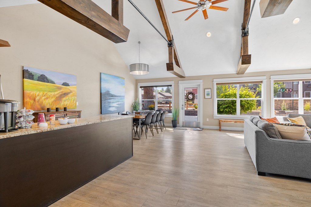 the living room and kitchen of a house with a large window and a kitchen island