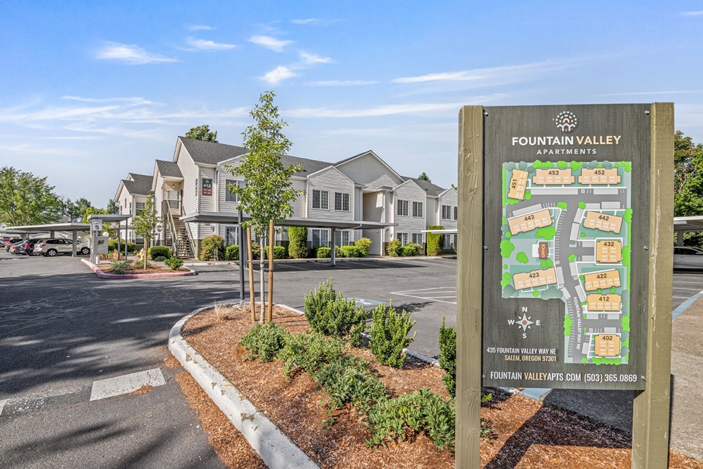 A sign for Fountain Valley Apartments is displayed in front of a building.