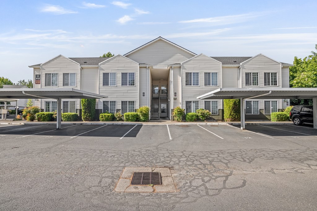 A large, modern building with a parking lot in front.