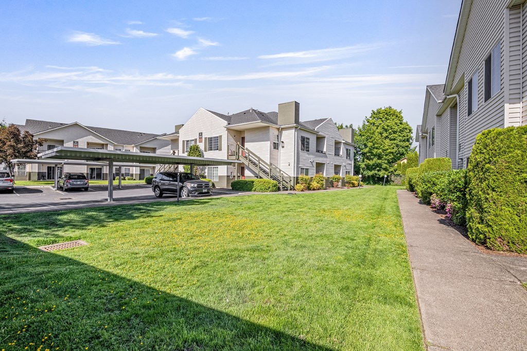 A sunny day at a residential area with houses and cars.