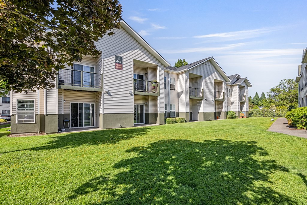 Apartment complex with green lawn in front.