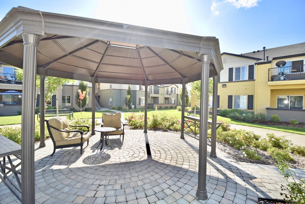 a gazebo with chairs and a table under it