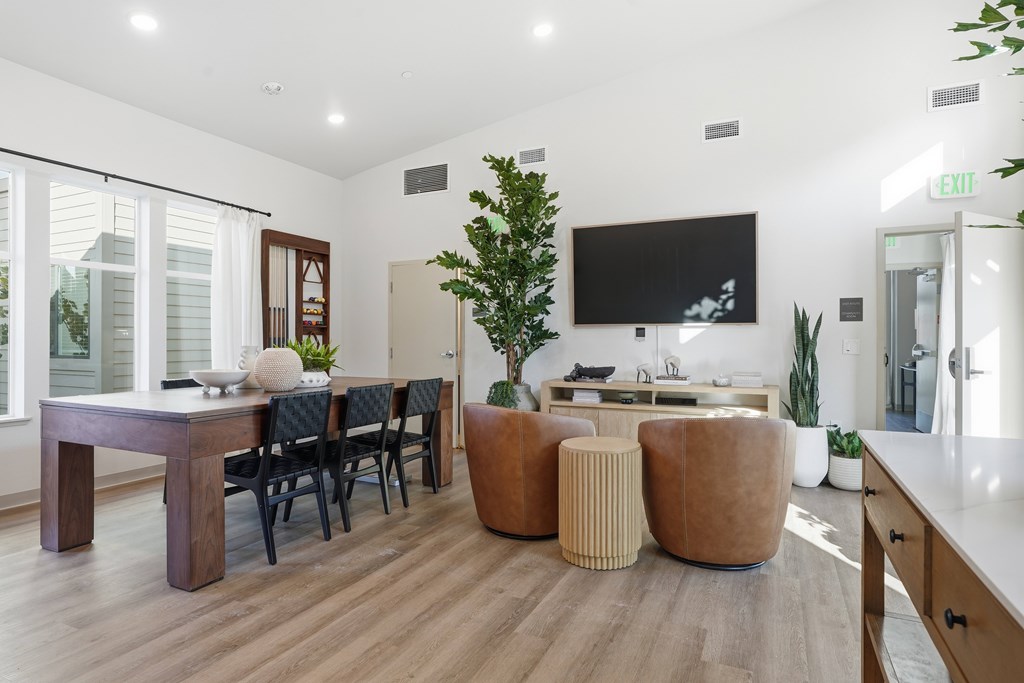 A modern living room with a dining table and chairs.