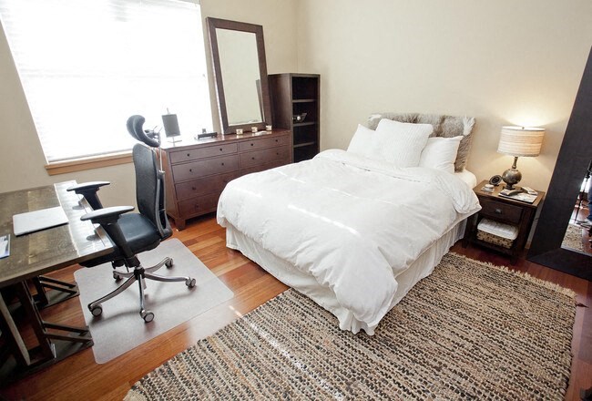 a bedroom with a bed and a desk and a chair