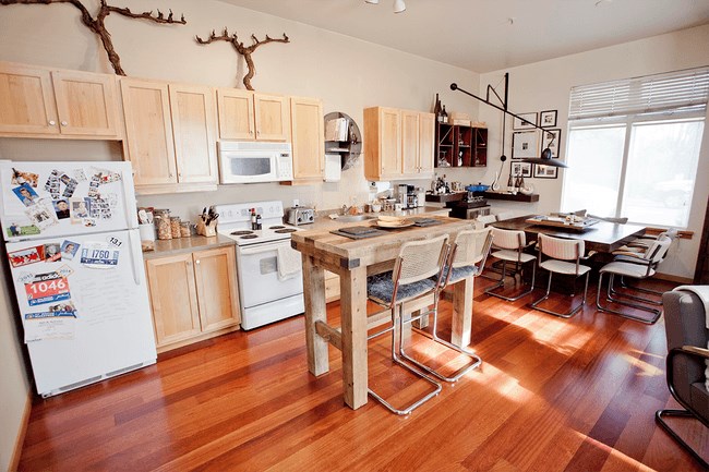 a large kitchen with a wooden table and chairs