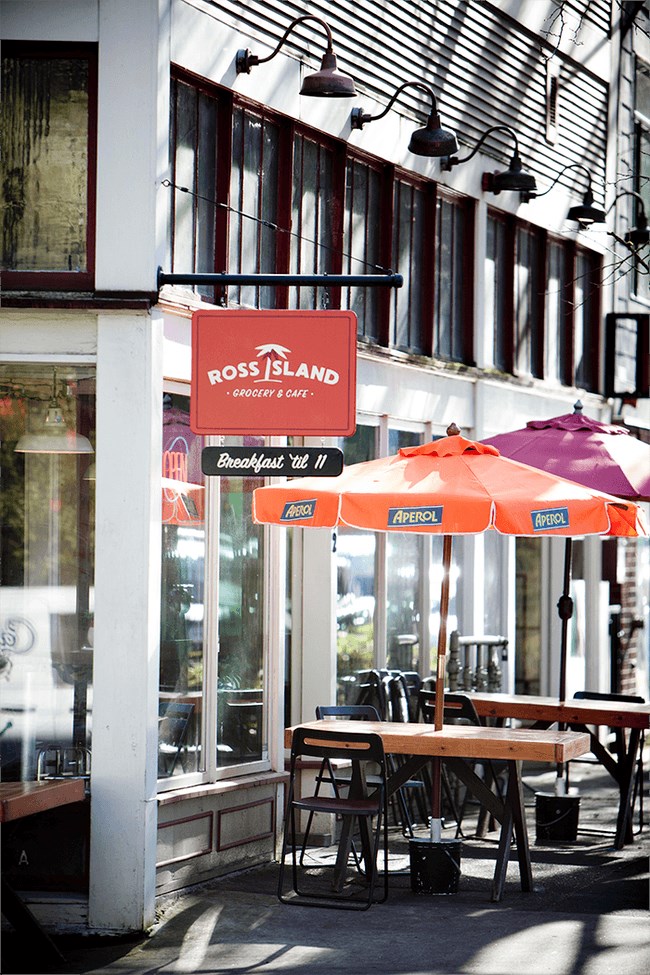 the outside of a restaurant with tables and umbrellas
