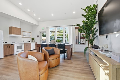 A modern living room with brown leather chairs and a flat screen TV.