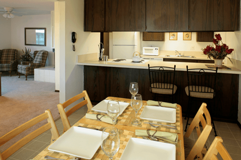 a dining room table with a kitchen in the background