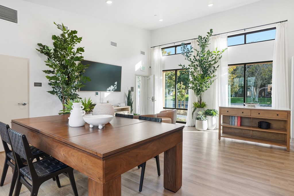 A modern dining room with a wooden table and chairs.