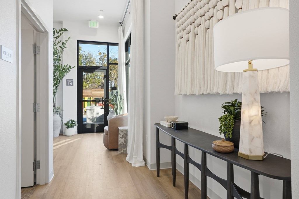 A hallway with a table and a lamp.