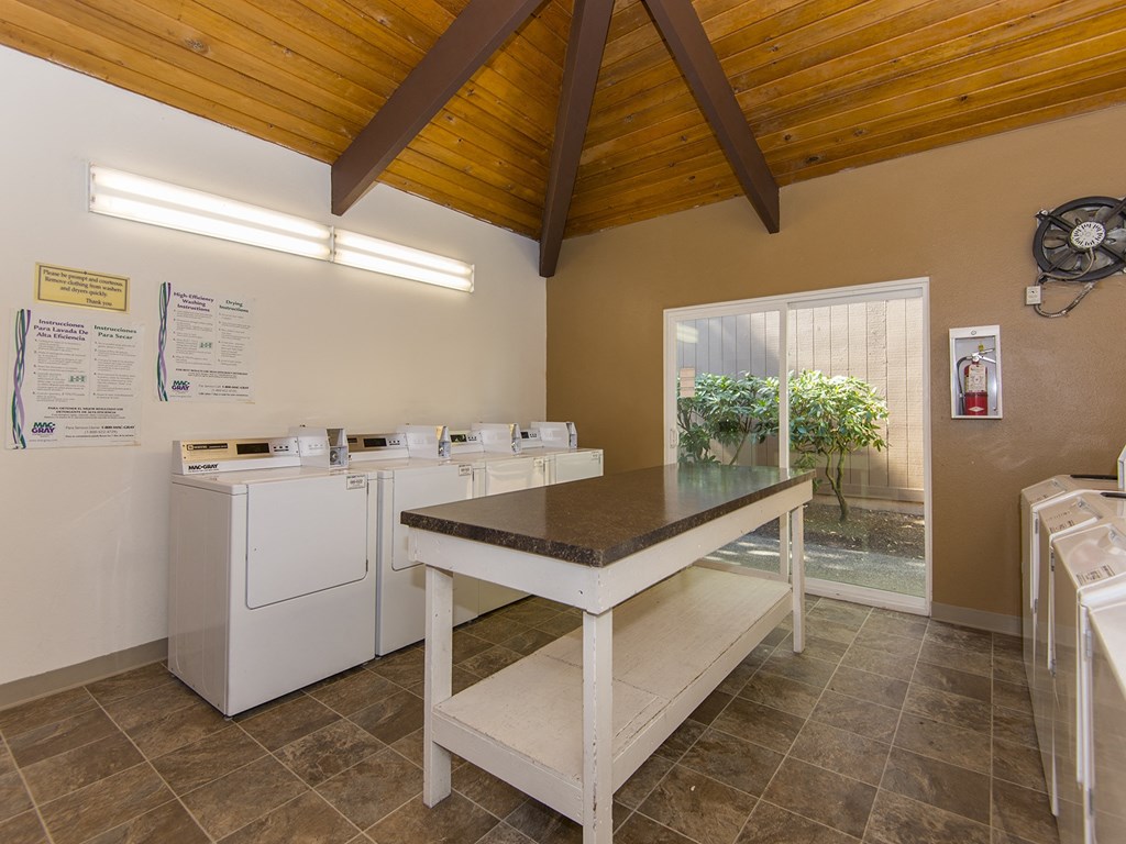 a laundry room with a table and washing machines