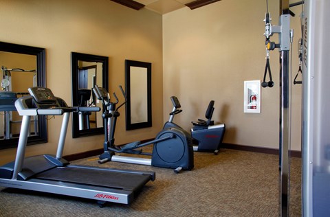a gym with treadmills and exercise equipment in a hotel room
