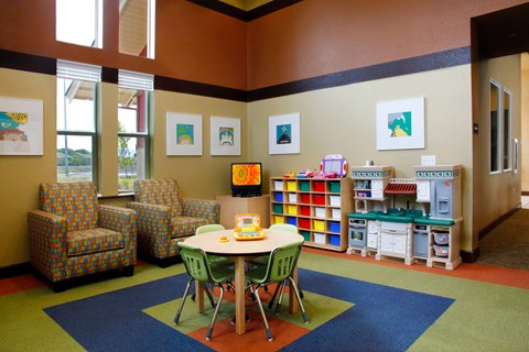 a childrens room with a table and chairs