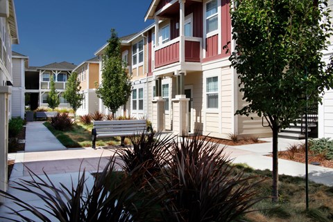 a park bench in front of a row of apartments