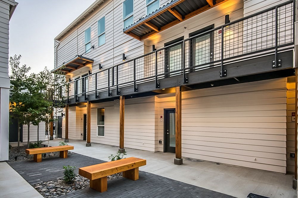 a building with a balcony and two benches on the sidewalk