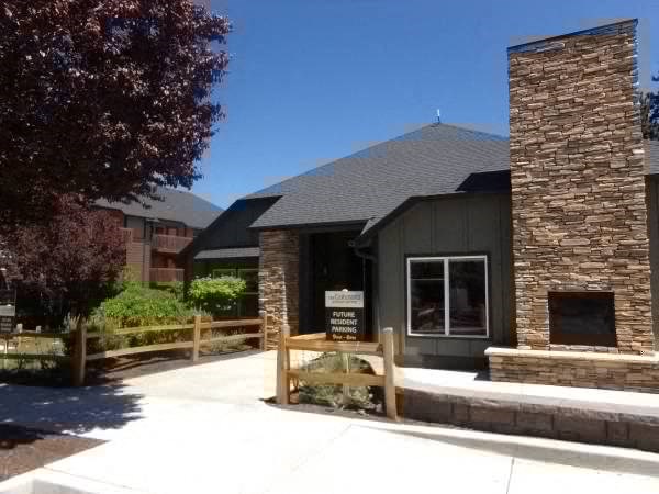 a stone building with a fence and a tree