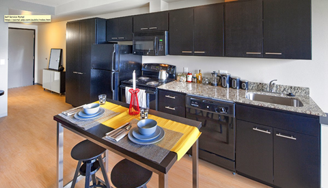 a kitchen with black cabinets and a table with chairs
