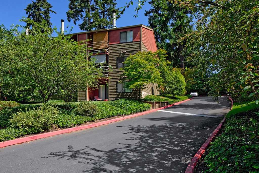 a red brick building with a black asphalt road in front of it