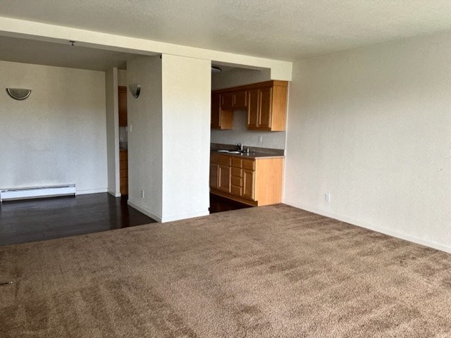 an empty living room with a kitchen in it