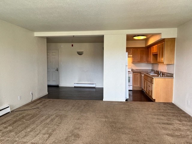 an empty living room with a kitchen in it